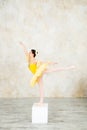Young modern ballerina in yellow dress posing in the light ballet room Royalty Free Stock Photo