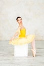 Young modern ballerina in yellow dress posing in the light ballet room Royalty Free Stock Photo