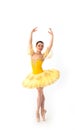 Young modern ballerina with yellow tutu doing the pose on white background Royalty Free Stock Photo