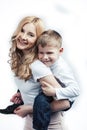 Young modern blond curly mother with cute son together happy smiling family posing cheerful on white background Royalty Free Stock Photo