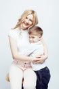 Young modern blond curly mother with cute son together happy smiling family posing cheerful on white background Royalty Free Stock Photo