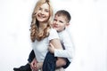 Young modern blond curly mother with cute son together happy smiling family posing cheerful on white background Royalty Free Stock Photo