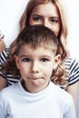 young modern blond mother with cute son together happy smiling family posing cheerful on white background, lifestyle