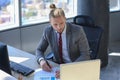 Young modern business man working using laptop while sitting in the office