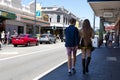 Young modern couple walking on the streets of an Australian town. Summer season. She has long blond hair. Fremantle, Australia