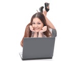 Young modern girl with laptop lying on the floor. isolated on a white background Royalty Free Stock Photo