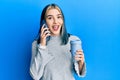 Young modern girl using smartphone and drinking a cup of coffee celebrating crazy and amazed for success with open eyes screaming Royalty Free Stock Photo