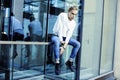 Young modern hipster guy at new building university blond fashion hairstyle having fun, lifestyle people concept Royalty Free Stock Photo