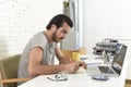 Young modern hipster style student or businessman working with laptop computer at home office writing Royalty Free Stock Photo