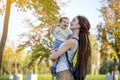 Young modern mom with baby son walking in Sunny Park. Concept of the joy of motherhood Royalty Free Stock Photo