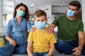 Young modern quarantined coronavirus family in medical masks