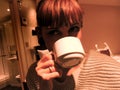 Young modern redhaired lonely woman drinking a cup of tea after a busy day at work - workaholic woman