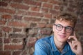 Young modern stylish businessman in glasses having cell telephone conversation Royalty Free Stock Photo