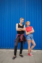 Young modern stylish hipsters couple on blue background, sunny portrait couple teenagers. Royalty Free Stock Photo