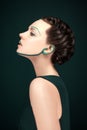 Young modern woman with green avantgarde make up and beautiful hair style