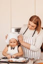 A young mom cheats on a little girl to cook buns. Parent and child spend time together
