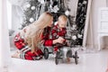 young mom with cute baby son in red checked pyjamas plays with toy retro grey car by festive decoration Christmas tree Royalty Free Stock Photo