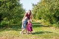 Young mom and cute little girls at the apple orchard Royalty Free Stock Photo
