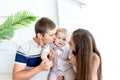 Young mom and dad kissing a child, parents with their son in a photo Studio, family day, happy family Royalty Free Stock Photo
