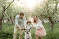 Young mom and dad teach their son to ride a bike