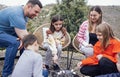 Young mom, dad, three daughters and son have fun in backyard of house and cook delicious treats on fire Royalty Free Stock Photo