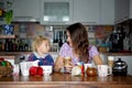 Young mom, drinking many coffees in the morning with her toddler child