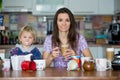 Young mom, drinking many coffees in the morning with her toddler child