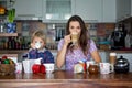 Young mom, drinking many coffees in the morning with her toddler child