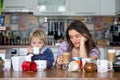 Young mom, drinking many coffees in the morning with her toddler child