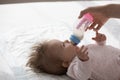 Young mom feeding sweet infant baby, giving formula Royalty Free Stock Photo