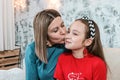 Young mom having kissing her daughte at christmas photo