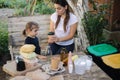 Young mom with her little daughter preparing for recycling different kind of rubbish and putting them into special Royalty Free Stock Photo