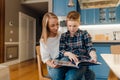 Young mom and her son reading book while sitting in kitchen Royalty Free Stock Photo