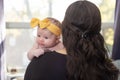 Young mom holding her newborn baby girl while staring out of window. Royalty Free Stock Photo