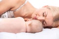Young mom lying in bed with baby