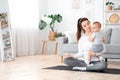 Young Mom Meditating With Baby On Arms, Practicing Yoga At Home Royalty Free Stock Photo