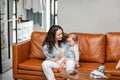 Young mom sitting with newborn son on sofa. Royalty Free Stock Photo