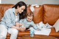 Young mom sitting with newborn son on sofa. Royalty Free Stock Photo