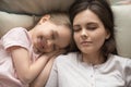 Young mom sleeping relaxing in bed with cute little daughter Royalty Free Stock Photo