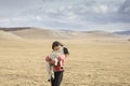 Young mongolian girl carrying a baby sheep in a steppe