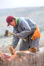 Young Mongolian man axing firewood.