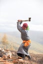 Young Mongolian man axing firewood.