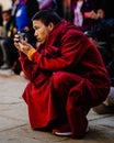 Young monk with cell phone observing Ancient Tibetan Buddhist Tiji Festival in Lo Manthang, Nepal