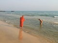 Young monk and child bathing in the sea