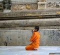 A young monk praying at the Buddhist temple in Delhi, India