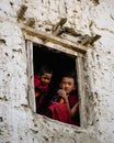 Young monks with cellphone observing Ancient Tibetan Buddhist Tiji Festival from window in Nepal