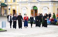 Young monks walk in Trinity Sergius Lavra along with visitors.