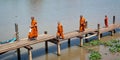 Young monks walking on a wooden boat pier at Inle lake in Burma Myanmar