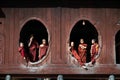 Young monks at window of wooden Church in temple.