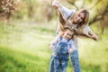 Young mother with adorable daughter in park with blossom tree